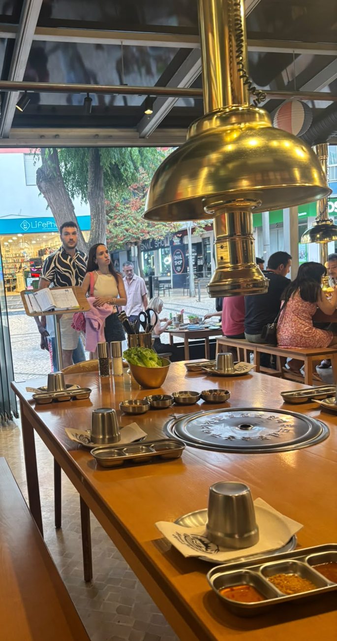 Carne a grelhar na grelha ao centro da mesa, no Hanam